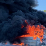 massive outdoor fire with black smoke and large flames