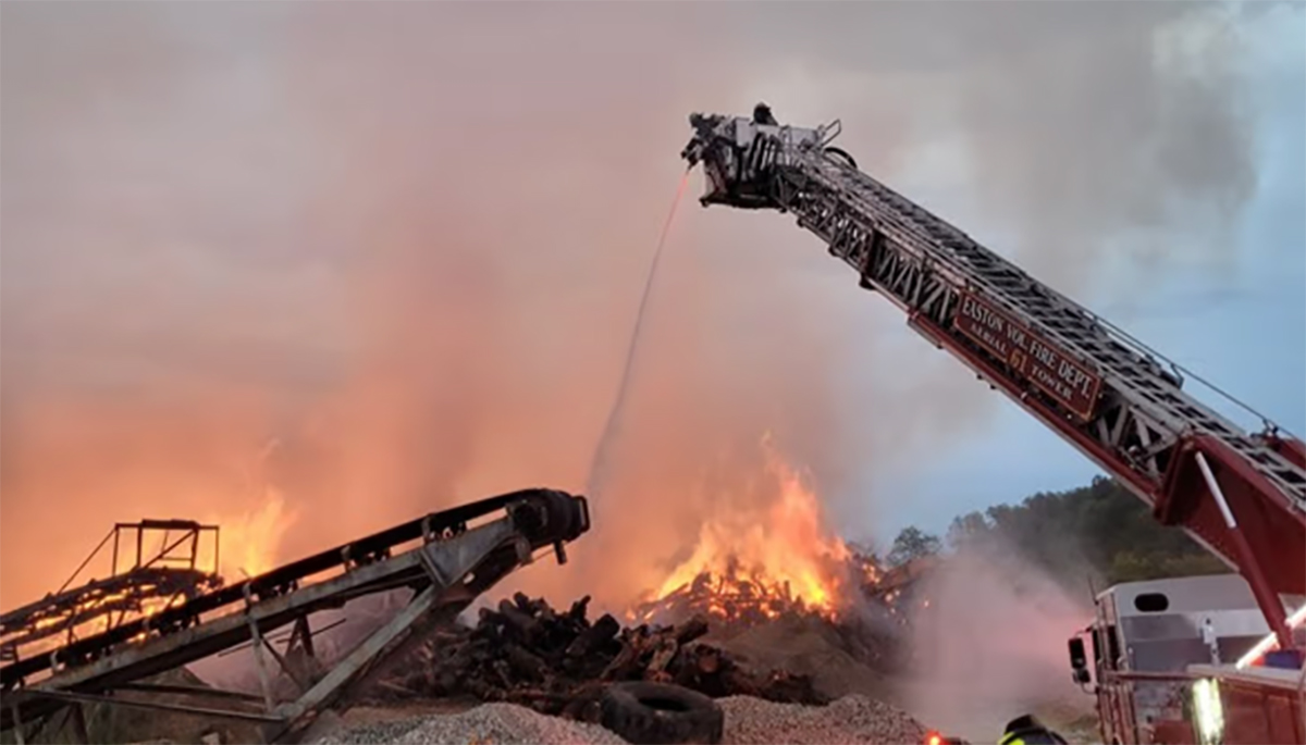 Cranes are putting out a fire in an industrial yard